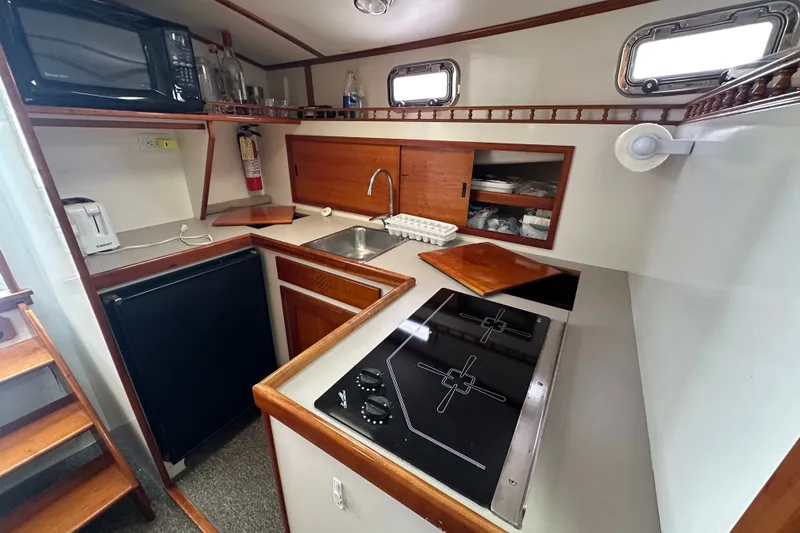 Slide: The Image of Compact kitchen in a 2001 Northern Bay 36 boat with stove, sink, and microwave. - 22