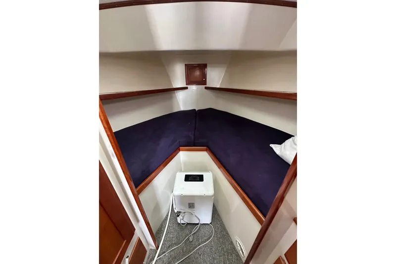 Slide: The Image of Cozy cabin interior of 2001 Northern Bay 36 boat with blue bedding and compact storage. - 21