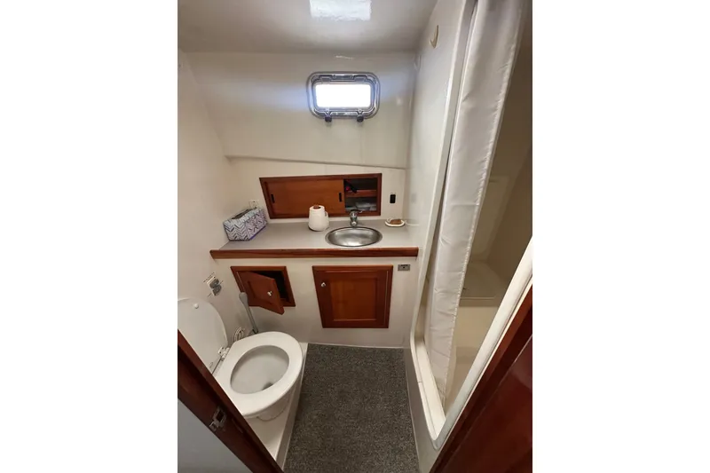 Slide: The Image of 2001 Northern Bay 36 boat bathroom with sink, toilet, and shower area. - 23