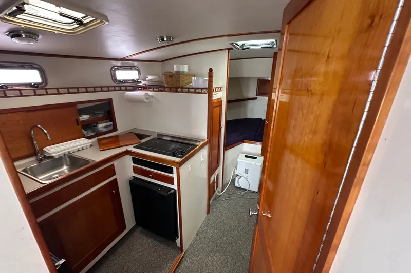 Slide: The Image of Interior of 2001 Northern Bay 36 boat featuring compact kitchen and cozy sleeping area. - 19