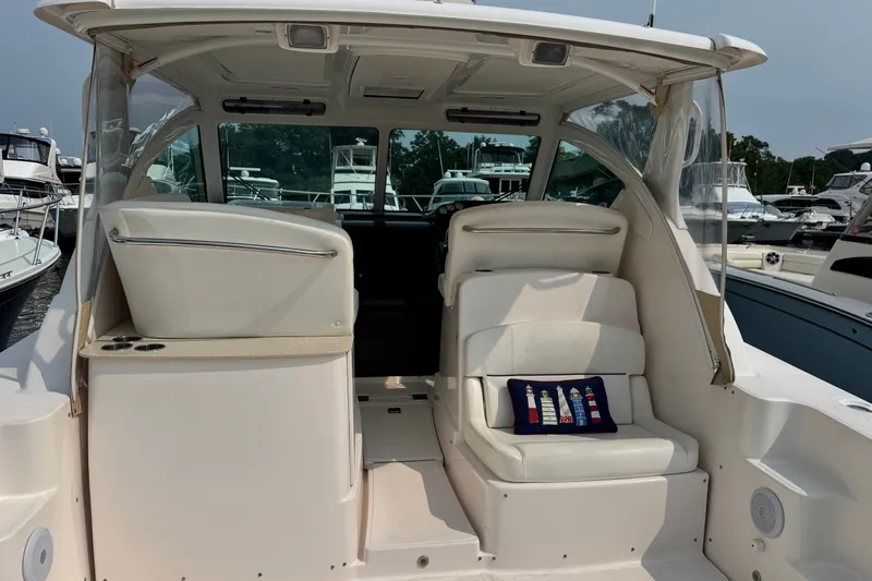Slide: The Image of 2008 Tiara 3000 Open yacht interior with white seating and nautical-themed pillow. - 3