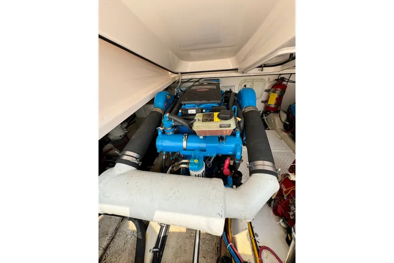 Slide: The Image of Engine compartment of a 2008 Tiara 3000 Open boat, showcasing blue engine components. - 31