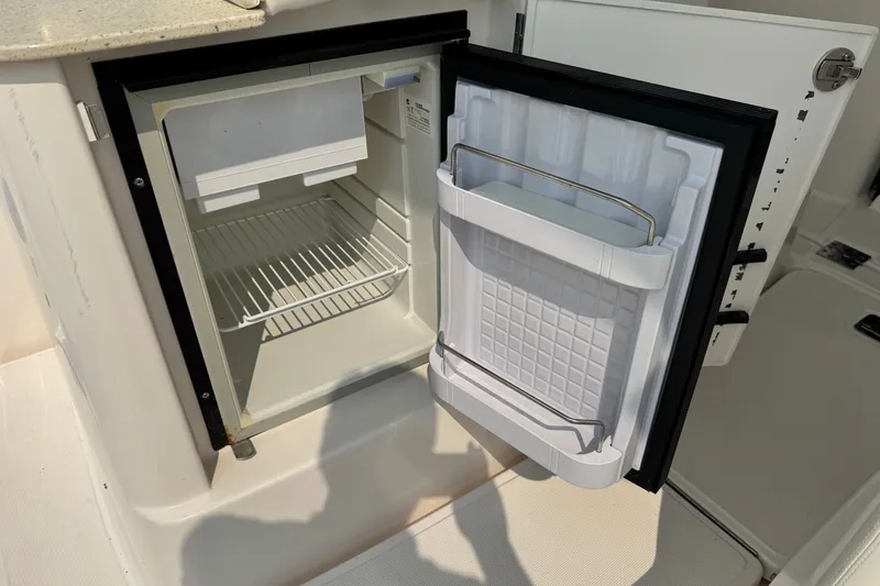 Slide: The Image of Open mini fridge on 2008 Tiara 3000 Open boat, showing interior shelves and door storage. - 15