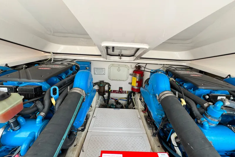 Slide: The Image of Engine room of a 2008 Tiara 3000 Open boat, featuring dual blue engines. - 30