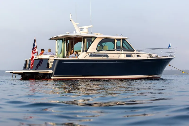 Slide: The Image of 2027 Sabre 45 Salon Express yacht on calm water with passengers enjoying the view. - 14