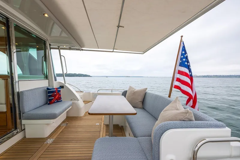 Slide: The Image of Luxurious 2027 Sabre 45 Salon Express yacht with elegant seating and American flag. - 7