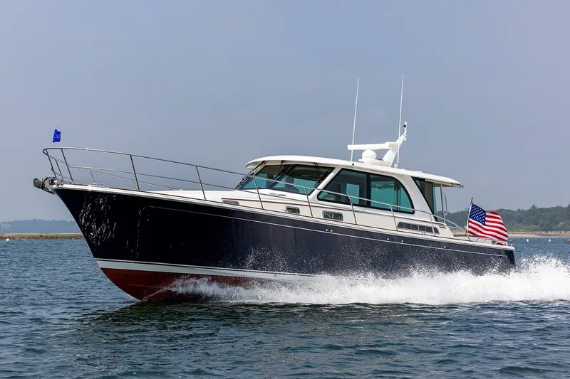 The Image of 2027 Sabre 45 Salon Express yacht cruising on open water with American flag. - 1