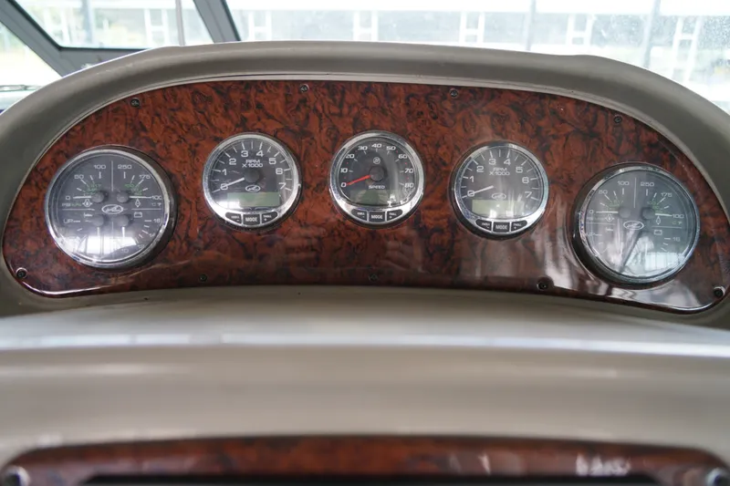 Slide: The Image of Dashboard of a 2006 Sea Ray 300 Sundancer boat with wood grain finish and gauges. - 22