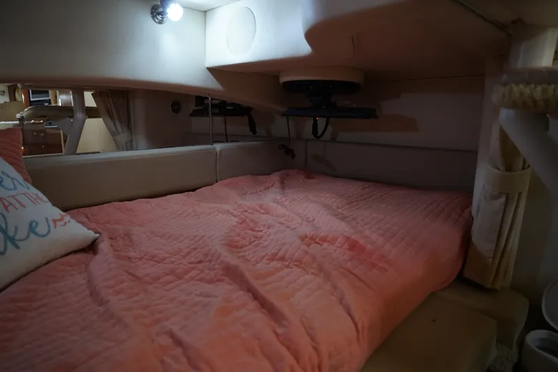 Slide: The Image of Cozy cabin interior of 2006 Sea Ray 300 Sundancer with pink bedding and ambient lighting. - 31