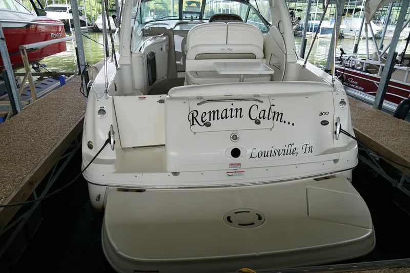 Slide: The Image of 2006 Sea Ray 300 Sundancer docked, featuring "Remain Calm" text on the stern. - 14