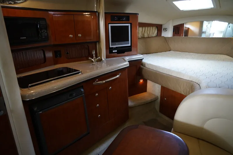 Slide: The Image of Interior of 2006 Sea Ray 300 Sundancer with kitchenette, bed, and entertainment area. - 26