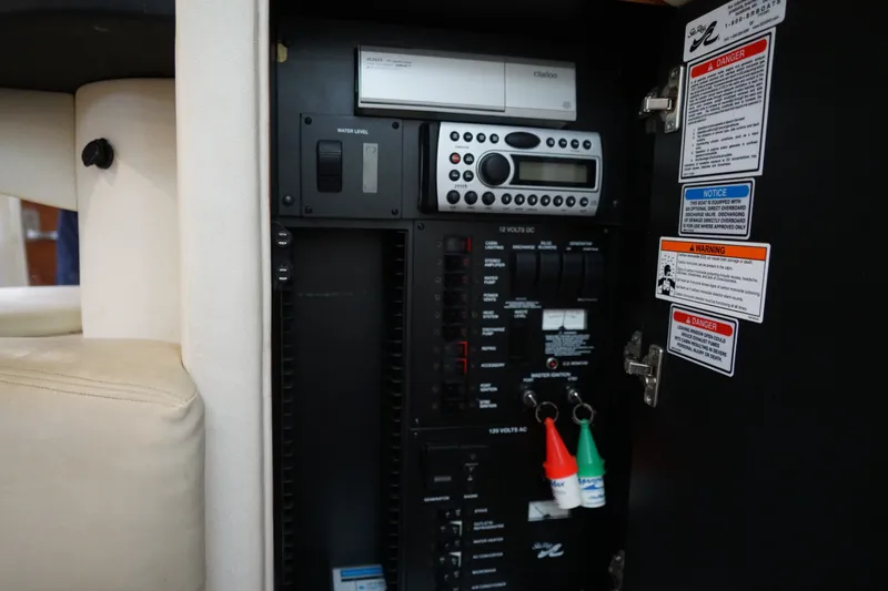 Slide: The Image of Control panel of a 2006 Sea Ray 300 Sundancer boat with warning labels and switches. - 34