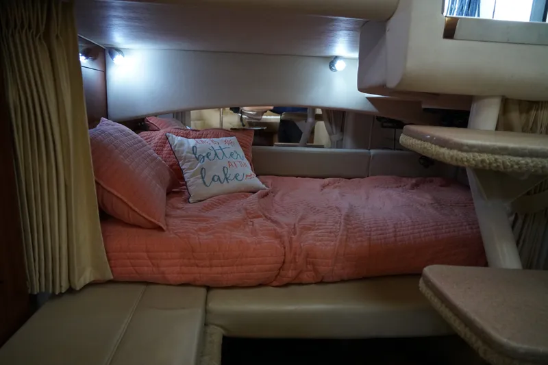 Slide: The Image of Cozy cabin interior of 2006 Sea Ray 300 Sundancer with pink bedding and decorative pillow. - 30