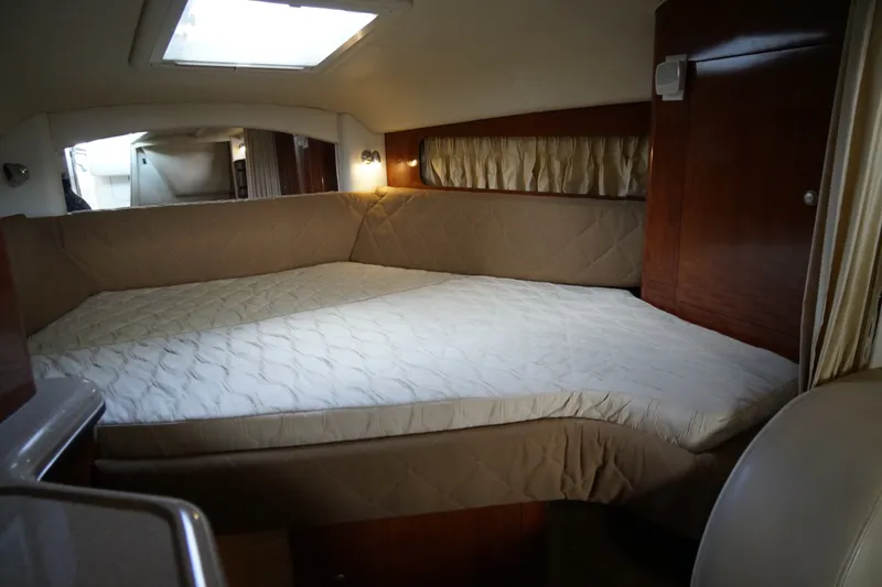 Slide: The Image of Interior cabin of 2006 Sea Ray 300 Sundancer with cozy bed and wood paneling. - 28