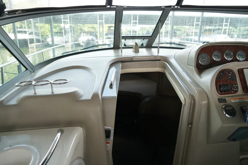 Slide: The Image of Interior view of a 2006 Sea Ray 300 Sundancer boat cockpit with dashboard and cabin entrance. - 24