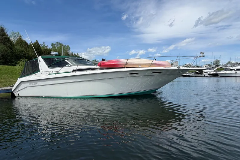 Slide: The Image of 1991 Sea Ray 350 Express Cruiser docked on calm water under a clear sky. - 2