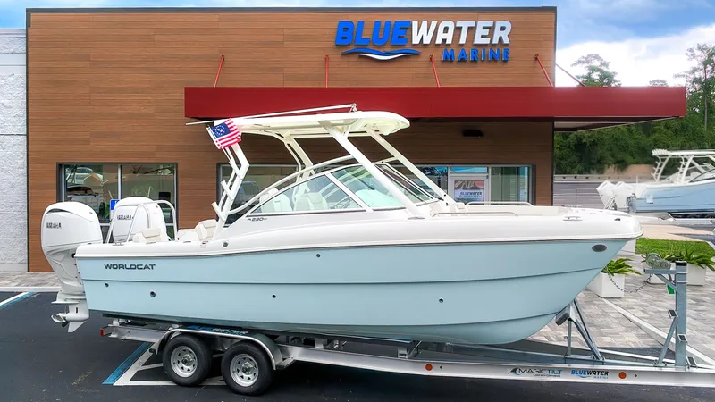 The Image of A 2027 World Cat 230 DC boat on a trailer in front of a Bluewater Marine building. - 1