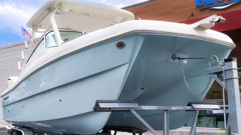 The Image of A 2027 World Cat 230 DC boat on a trailer, featuring a blue hull and white roof. - 1