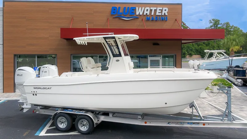 The Image of A 2027 World Cat 235 TE boat on a trailer in front of a Bluewater Marine building. - 1