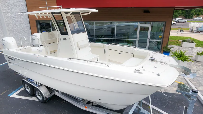 The Image of A modern catamaran with twin outboard engines on a trailer, parked in front of a building. - 1