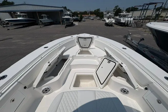 Slide: The Image of 2027 Regulator 30XO boat deck with open storage compartments in a marina setting. - 20