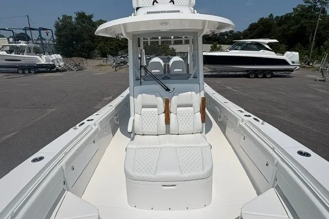 Slide: The Image of 2027 Regulator 30XO boat with luxurious seating and sleek design in a marina setting. - 27
