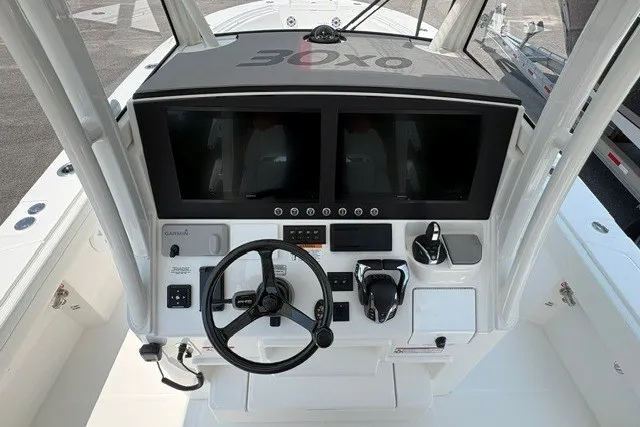 Slide: The Image of 2027 Regulator 30XO boat dashboard with dual screens and steering wheel. - 13