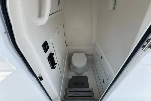Slide: The Image of 2027 Regulator 30XO boat interior with compact marine toilet and storage compartments. - 18