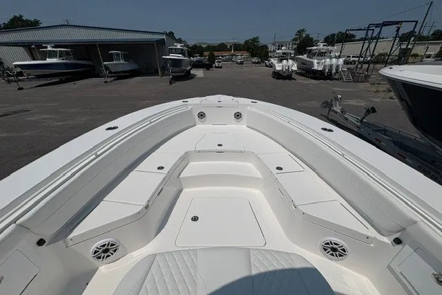Slide: The Image of 2027 Regulator 30XO boat deck with seating, parked in a marina with other boats. - 19
