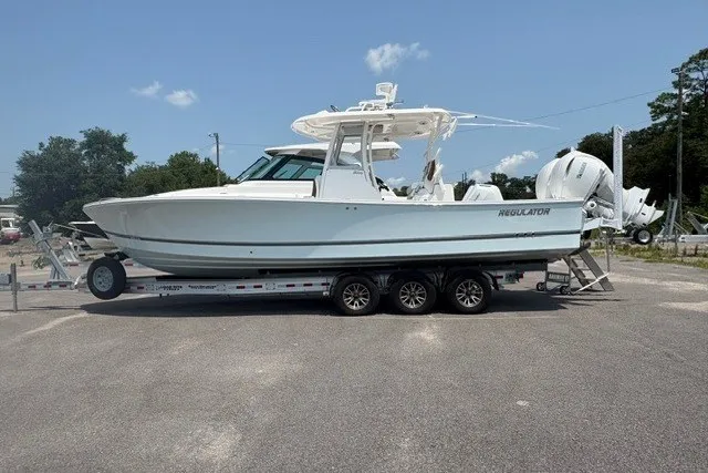 The Image of 2027 Regulator 30XO boat on trailer, side view, parked outdoors under clear sky. - 0