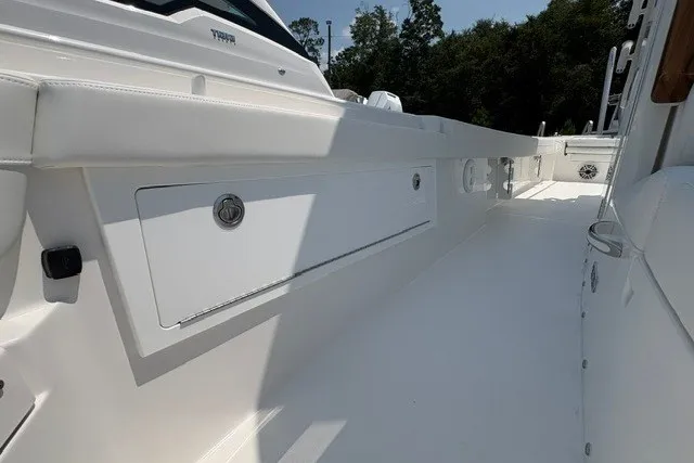 Slide: The Image of 2027 Regulator 30XO boat interior with sleek white design and storage compartments. - 16