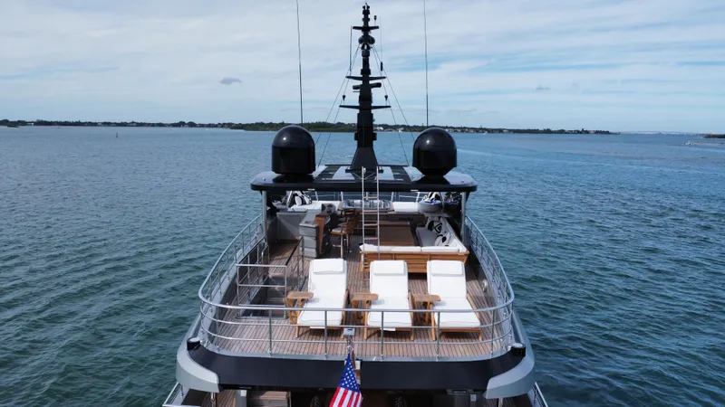 Slide: The Image of Majesty 120 yacht, 2025 model, cruising on open water with deck chairs and American flag. - 11