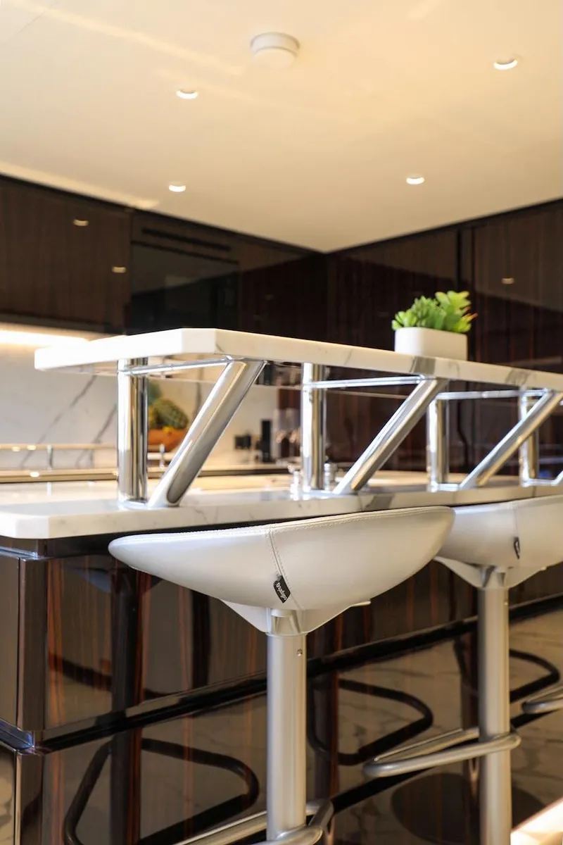 Slide: The Image of Modern kitchen interior with sleek bar stools and contemporary design, Majesty 120 yacht, 2025 model. - 39
