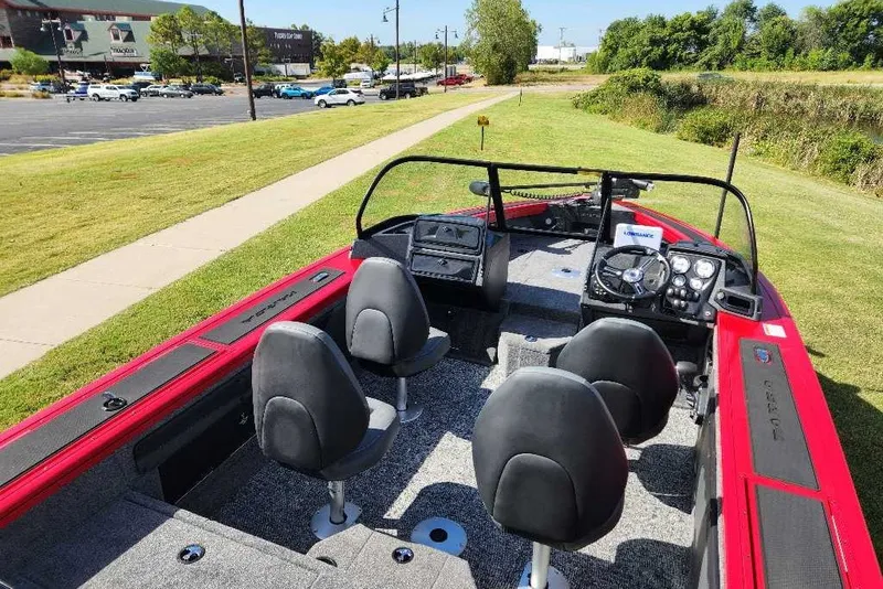 Slide: The Image of 2026 Tracker Targa V-19 WT boat with red accents, parked on grassy area. - 14