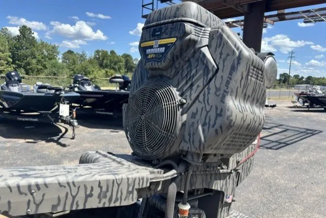 Slide: The Image of 2026 Tracker Grizzly 1650 T Prairie Wings Edition boat with camo design, parked outdoors. - 14