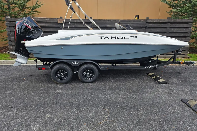 The Image of 2026 Tahoe 1950 boat on trailer, parked outdoors, side view. - 0