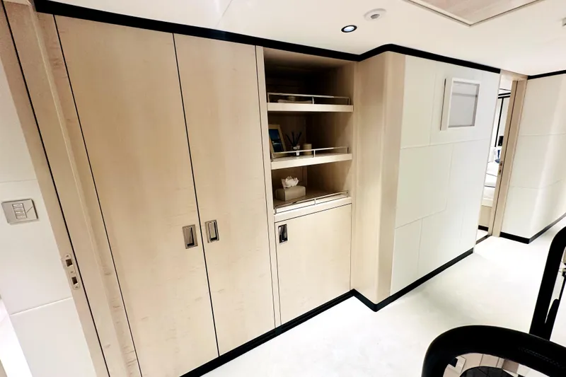Slide: The Image of Modern interior of 2023 Majesty 120 yacht with sleek wooden cabinetry and open shelving. - 36