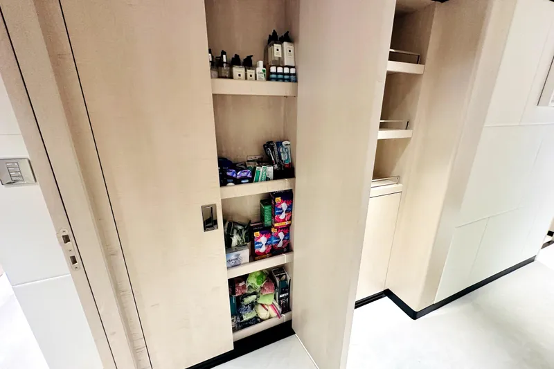 Slide: The Image of Modern pantry shelves in a 2023 Majesty 120 yacht, stocked with toiletries and snacks. - 37