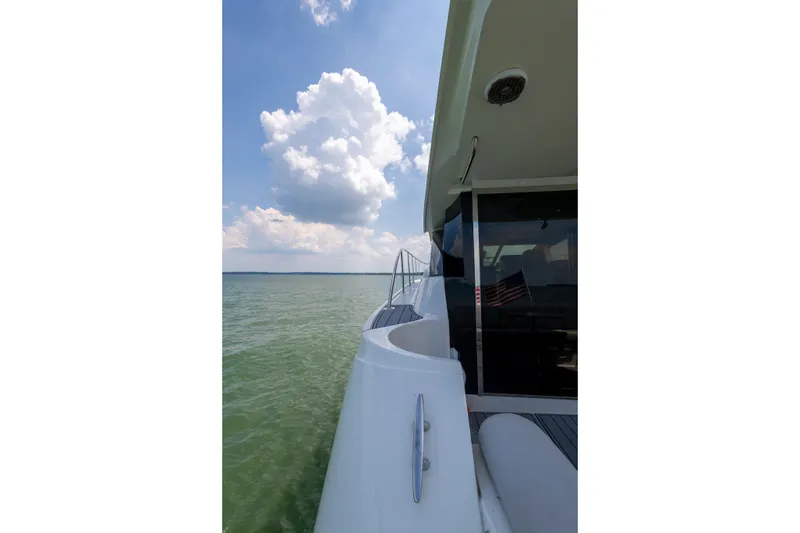 Slide: The Image of 2017 Sea Ray Fly 510 yacht cruising on calm waters under a cloudy sky. - 8