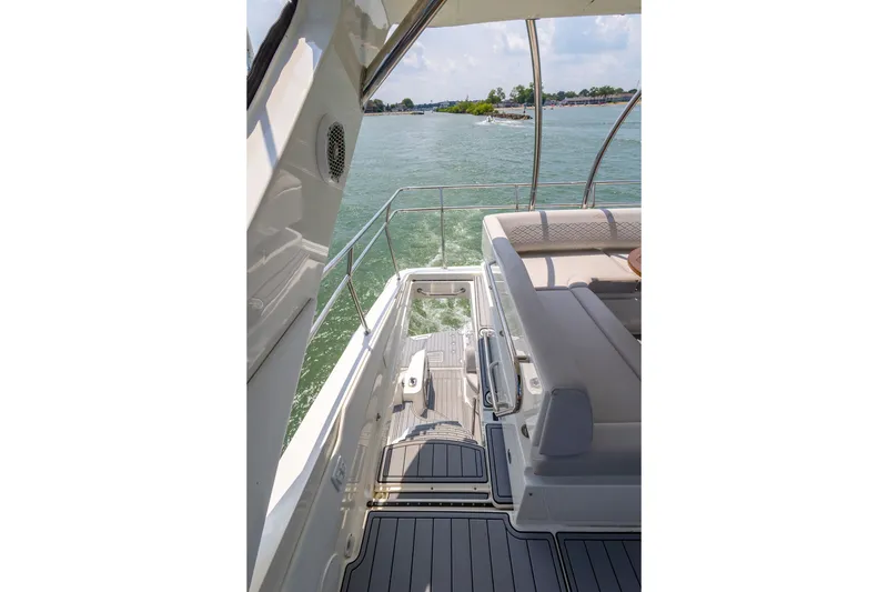 Slide: The Image of 2017 Sea Ray Fly 510 yacht deck with seating, overlooking calm waters. - 10