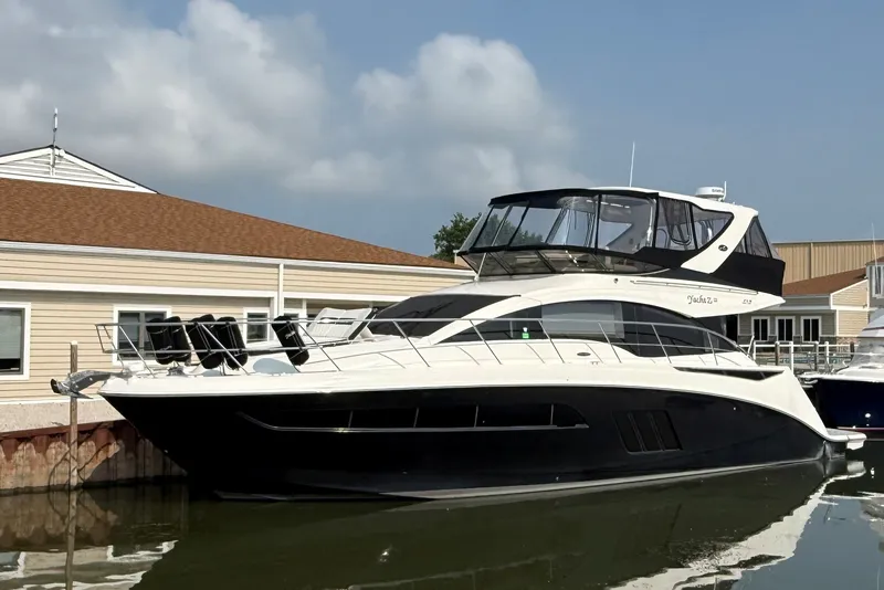 The Image of 2017 Sea Ray Fly 510 yacht docked at marina, featuring sleek design and spacious upper deck. - 0