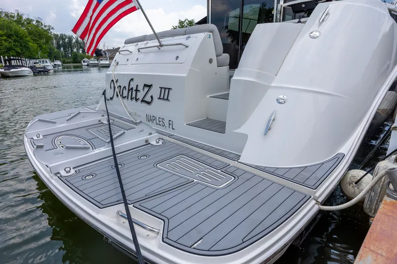 Slide: The Image of 2017 Sea Ray Fly 510 yacht docked, featuring sleek design and American flag. - 4