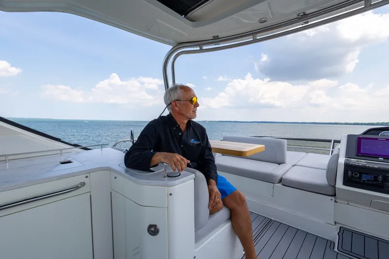 Slide: The Image of Man relaxing on a 2017 Sea Ray Fly 510 yacht, enjoying ocean views. - 19