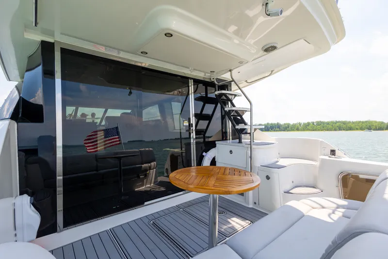 Slide: The Image of Luxurious 2017 Sea Ray Fly 510 yacht deck with seating, table, and American flag. - 23