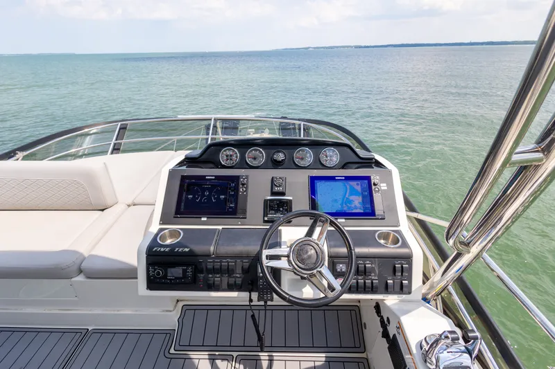 Slide: The Image of 2017 Sea Ray Fly 510 yacht helm with navigation screens and ocean view. - 16