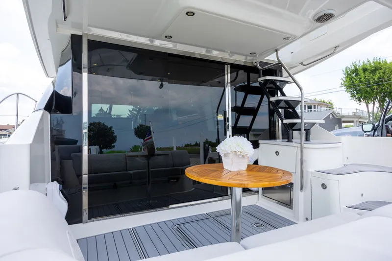 Slide: The Image of 2017 Sea Ray Fly 510 yacht deck with table, stairs, and seating area. - 5