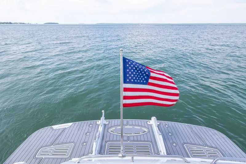 Slide: The Image of American flag on 2017 Sea Ray Fly 510 yacht, overlooking serene ocean waters. - 20