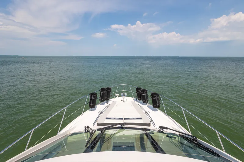 Slide: The Image of 2017 Sea Ray Fly 510 yacht cruising on open water under a clear blue sky. - 17