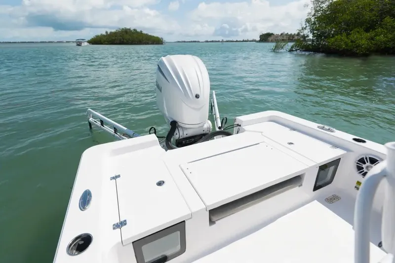 Slide: The Image of 2027 Sportsman Masters 247OE Bay Boat on calm water, showcasing rear deck and motor. - 11