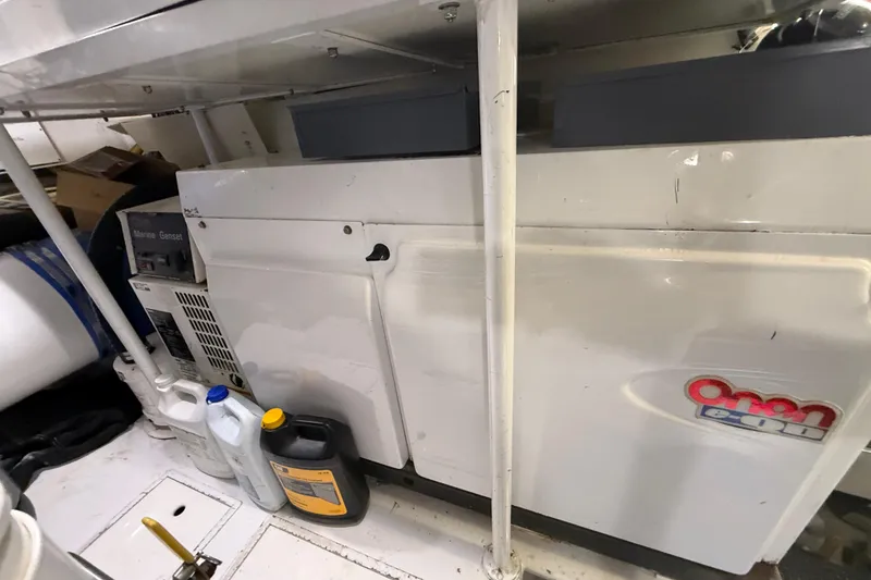 Slide: The Image of Engine room of 2004 Viking 65 Enclosed Bridge with Onan generator and maintenance supplies. - 84